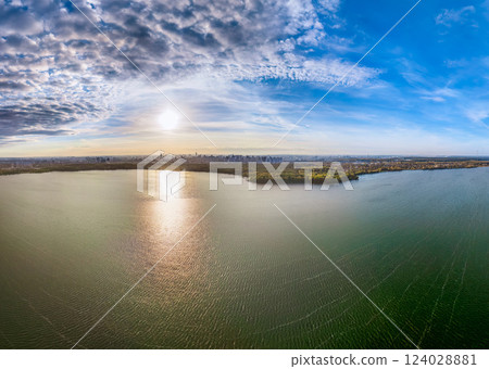 Autumn forest on lake shore at sunset and city on horizon, auerial view 124028881