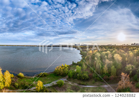 Autumn forest on lake shore at sunset and city on horizon, auerial view Autumn forest on lake shore at sunset and city on horizon, auerial view 124028882