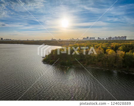 Autumn forest on lake shore at sunset and city on horizon, auerial view 124028889
