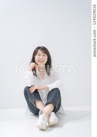 中年婦女微笑地坐著 中年婦女微笑地坐著 124029016