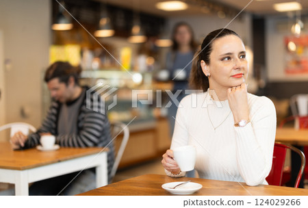 Woman whiles away time and waits for meeting in chain cafe Woman whiles away time and waits for meeting in chain cafe 124029266