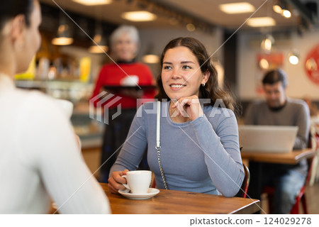 Two women talking over cup of coffee in cafe Two women talking over cup of coffee in cafe 124029278
