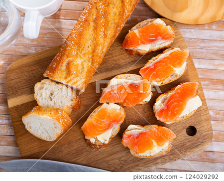 Sandwiches with smoked salmon and butter on wooden board Sandwiches with smoked salmon and butter on wooden board 124029292