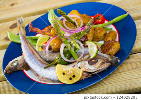 Whiting stewed in white wine with baked potatoes, fresh pea pods 124029293