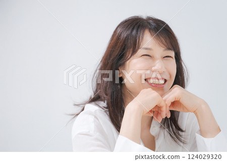Middle-aged woman sitting with a smile Middle-aged woman sitting with a smile 124029320