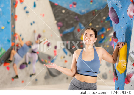 Young woman posing on climbing wall 124029388