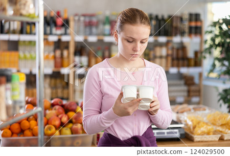 Young girl choosing yogurt in grocery store Young girl choosing yogurt in grocery store 124029500