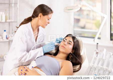 European doctor making Beauty procedure to brunette girl (skin cleaning) European doctor making Beauty procedure to brunette girl (skin cleaning) 124029722