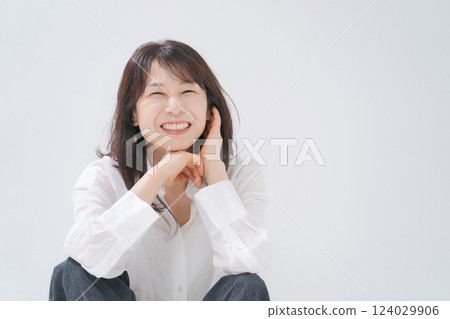 A woman in her 50s sitting with a smile A woman in her 50s sitting with a smile 124029906
