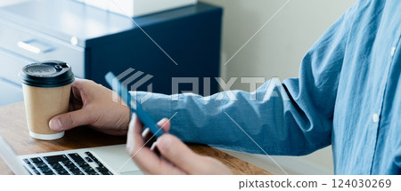 一名男子操作智慧型手機和電腦 一名男子操作智慧型手機和電腦 124030269