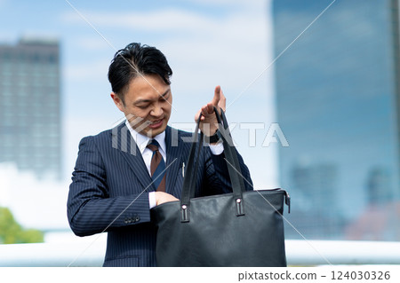 Businessman searching for luggage Businessman searching for luggage 124030326