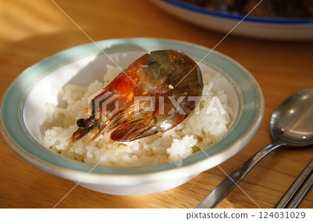 A traditional Korean dish, soy sauce shrimp, is placed on top of white rice. 124031029