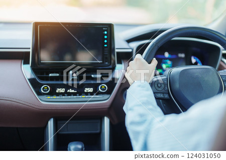 Businesswoman driver driving a car on the road, hand controlling steering wheel in electric modern automobile. Journey, trip and safety Transportation concepts Businesswoman driver driving a car on the road, hand controlling steering wheel in electric modern automobile. Journey, trip and safety Transportation concepts 124031050