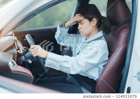 woman feeling stress and angry during drive car long time. Asian girl tired and fatigue having headache after driving car in traffic jam. Sleepy, stretching and drunk concept woman feeling stress and angry during drive car long time. Asian girl tired and fatigue having headache after driving car in traffic jam. Sleepy, stretching and drunk concept 124031079