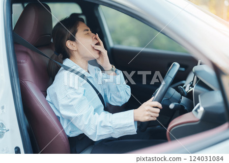 woman feeling sleepy and yawn during drive car long time. Asian girl tired and fatigue having headache after driving car in traffic jam. Sleep, stretching and safety concept 124031084