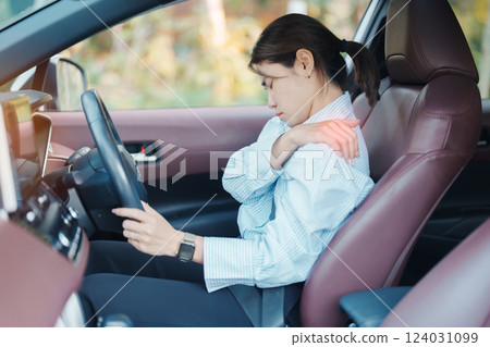 woman with her shoulder and neck sprain while driving car long time, muscle painful. Shoulder ache, Scapular pain, office syndrome and ergonomic concept 124031099