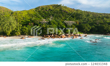A beautiful, untouched beach meets the foot of a vibrant green hillside. Anse Lazio, Seychelles. 124031348
