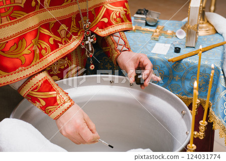Priest Preparing Baptism Water with Holy Oil Priest Preparing Baptism Water with Holy Oil 124031774