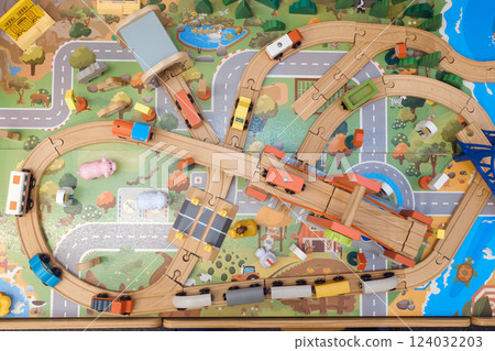 Colorful wooden train set with vehicles on a vibrant play mat depicting roads and nature, encouraging imaginative play in kids during afternoon hours Colorful wooden train set with vehicles on a vibrant play mat depicting roads and nature, encouraging imaginative play in kids during afternoon hours 124032203