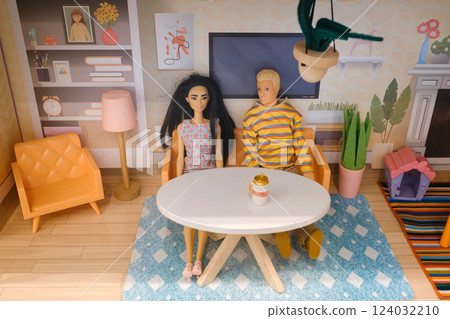Couple enjoys a cozy afternoon in a stylish dollhouse living room decorated with modern furniture and bright colors Couple enjoys a cozy afternoon in a stylish dollhouse living room decorated with modern furniture and bright colors 124032210