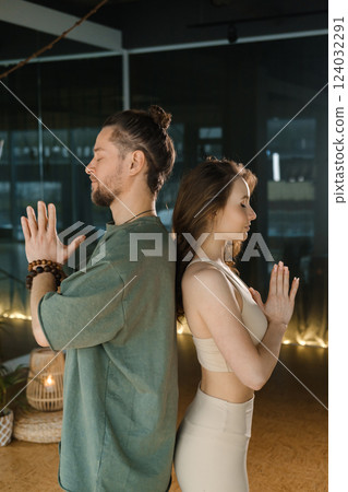 Meditation practice with a male and female yogi in a serene indoor space during evening hours promoting mindfulness and relaxation through yoga 124032291
