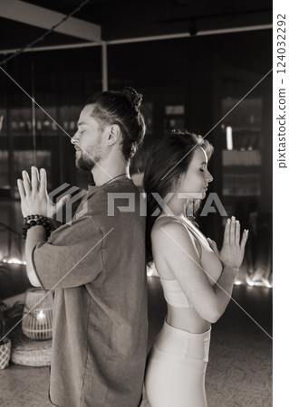 Meditation practice with a male and female yogi in a serene indoor space during evening hours promoting mindfulness and relaxation through yoga 124032292