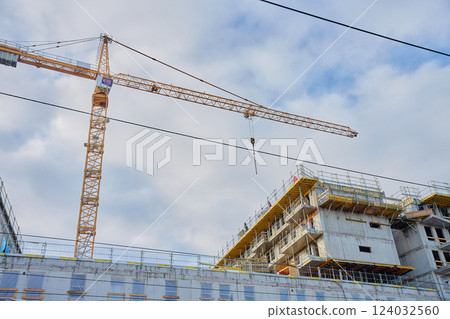 Modern building under construction with concrete structure and cranes 124032560