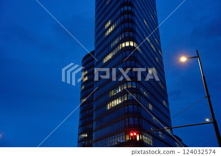 Modern high-rise office building with illuminated windows at night 124032574