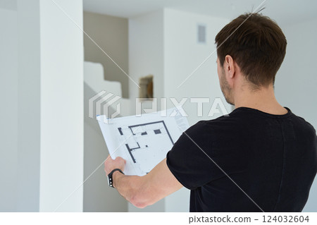 Man analyzing architectural blueprint in new home 124032604
