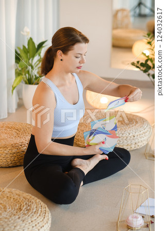A sporty girl lays out Tarot cards indoors. Tarot cards in the hands of a fortune teller 124032617