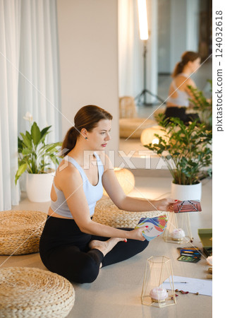 A sporty girl lays out Tarot cards indoors. Tarot cards in the hands of a fortune teller 124032618