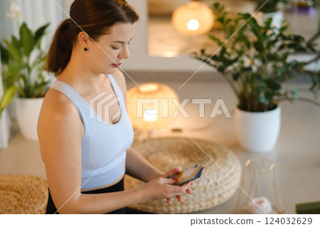 A sporty girl lays out Tarot cards indoors. Tarot cards in the hands of a fortune teller 124032629