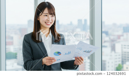 A smiling female office worker is showing documents and explaining to her boss or client. Presentation 124032691