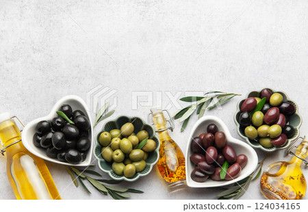 Black, green and kalamata olives with olive oil and olive branches  124034165