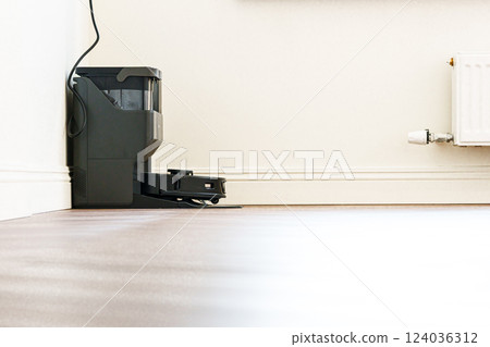 Robotic Vacuum Cleaner Charging Battery Smart Cleaning Technology. Modern smart electronic housekeeping technology 124036312