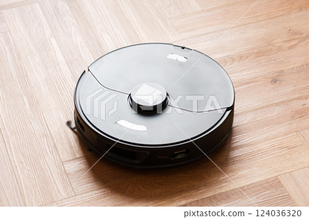 Robot vacuum cleaner performs automatic cleaning of the apartment at a certain time. Smart home. Robot vacuum cleaner performs automatic cleaning of the apartment at a certain time. Smart home. 124036320