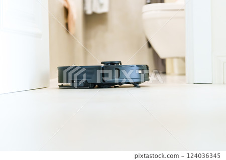 Robot vacuum cleaner performs automatic cleaning of the apartment at a certain time. Smart home. Robot vacuum cleaner performs automatic cleaning of the apartment at a certain time. Smart home. 124036345