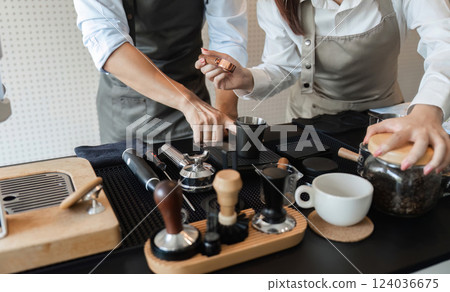 Coffee Preparation and Artisan Skills. Baristas collaboratively showcasing their skills in brewing and serving coffee. 124036675
