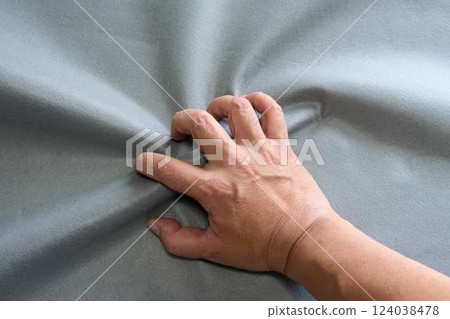 Male hand grabbing a grey cloth Male hand grabbing a grey cloth 124038478