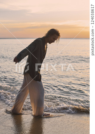 happy boy on the beach at sunset. young handsome wet man happy boy on the beach at sunset. young handsome wet man 124038617