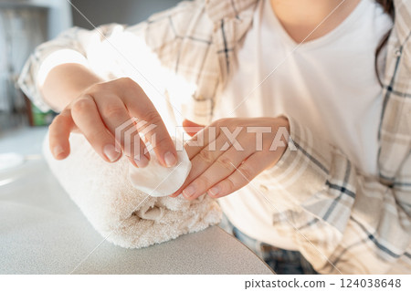 Nail care process: pushing back cuticles and applying vitamin-infused treatment polish to strengthen nails. 124038648