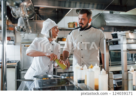 Man and woman cooking meal. Professional chef preparing food in the kitchen 124039171