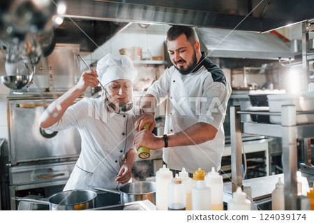 Man and woman cooking meal. Professional chef preparing food in the kitchen 124039174
