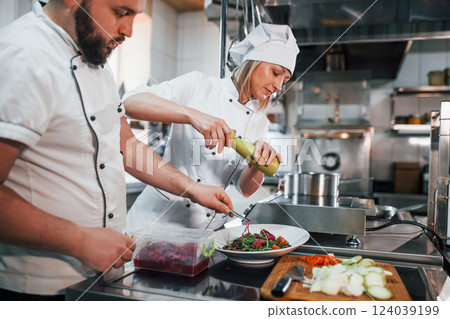 Three people. Making vegan salad. Professional chef preparing food in the kitchen 124039199