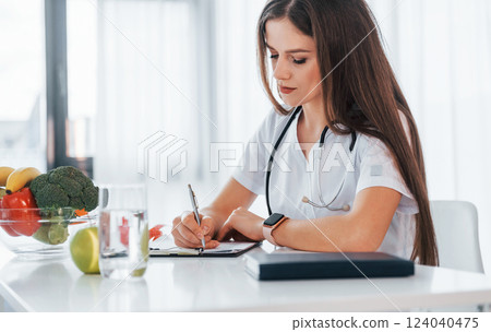 Professional medical worker in white coat is in the office Professional medical worker in white coat is in the office 124040475