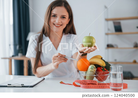 Many of the fruits. Professional medical worker in white coat is in the office 124040500