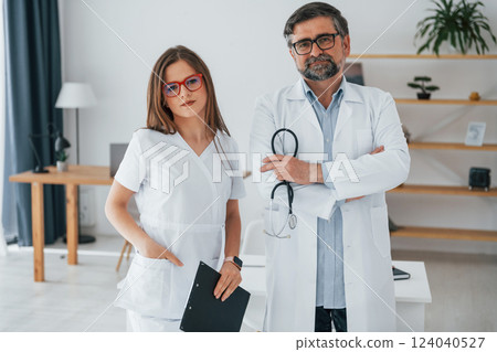Woman and man standing together. Professional medical workers in white coats is in the office 124040527