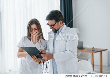 Reading information. Professional medical workers in white coats is in the office Reading information. Professional medical workers in white coats is in the office 124040531