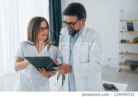 Reading information. Professional medical workers in white coats is in the office 124040532