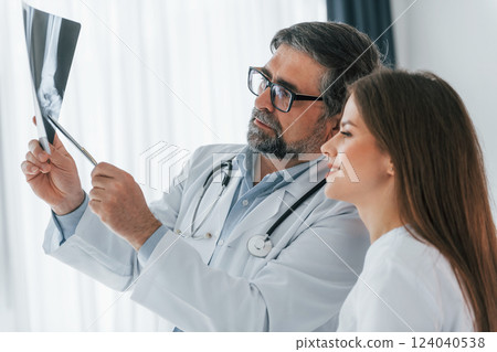Traumatic picture on the x-ray. Professional medical workers in white coats is in the office 124040538